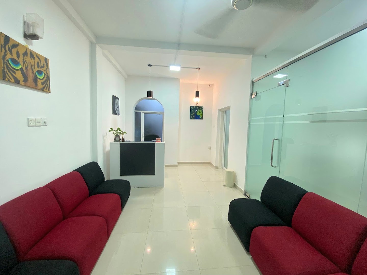 Bright reception area with cool mint glass and red and black seating